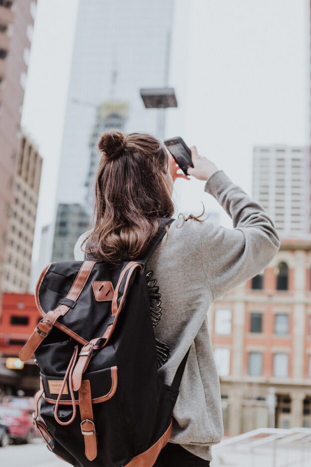 什么样的照片有长期的留存价值? - 1 woman taking photo of high-rise building beside road