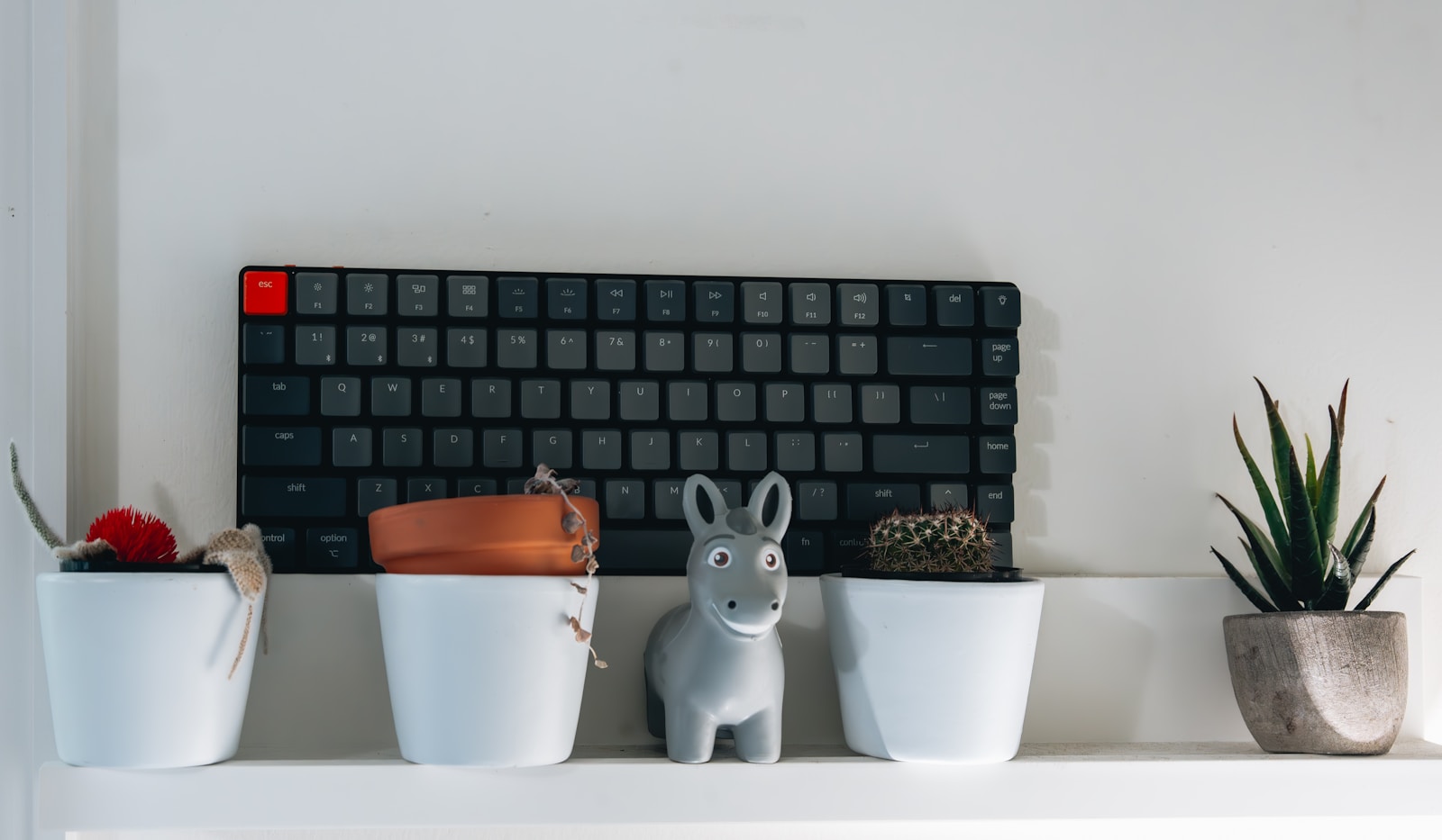 a keyboard sitting on top of a white shelf
